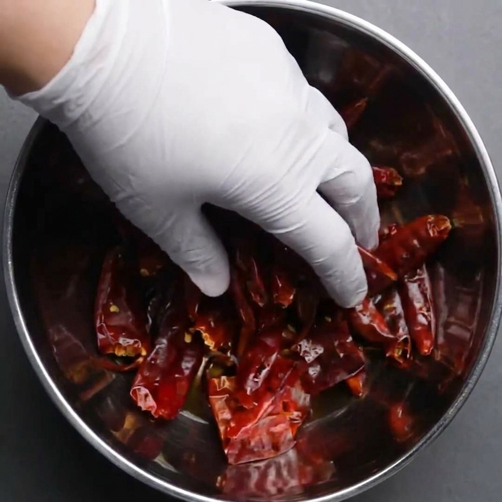Ganze getrocknete rote Chilis werden in einer Schüssel mit Wasser zum Einweichen untergetaucht.