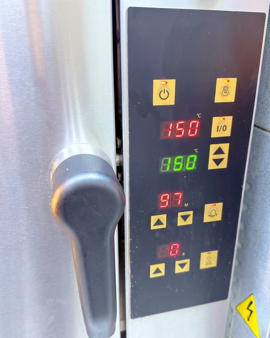 Bedienfeld eines Ofens mit einer Temperaturanzeige von 150 Grad Celsius.