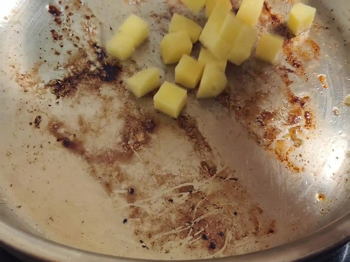 Kartoffelwürfel werden in der Pfanne im heißen Speckfett geschwenkt.