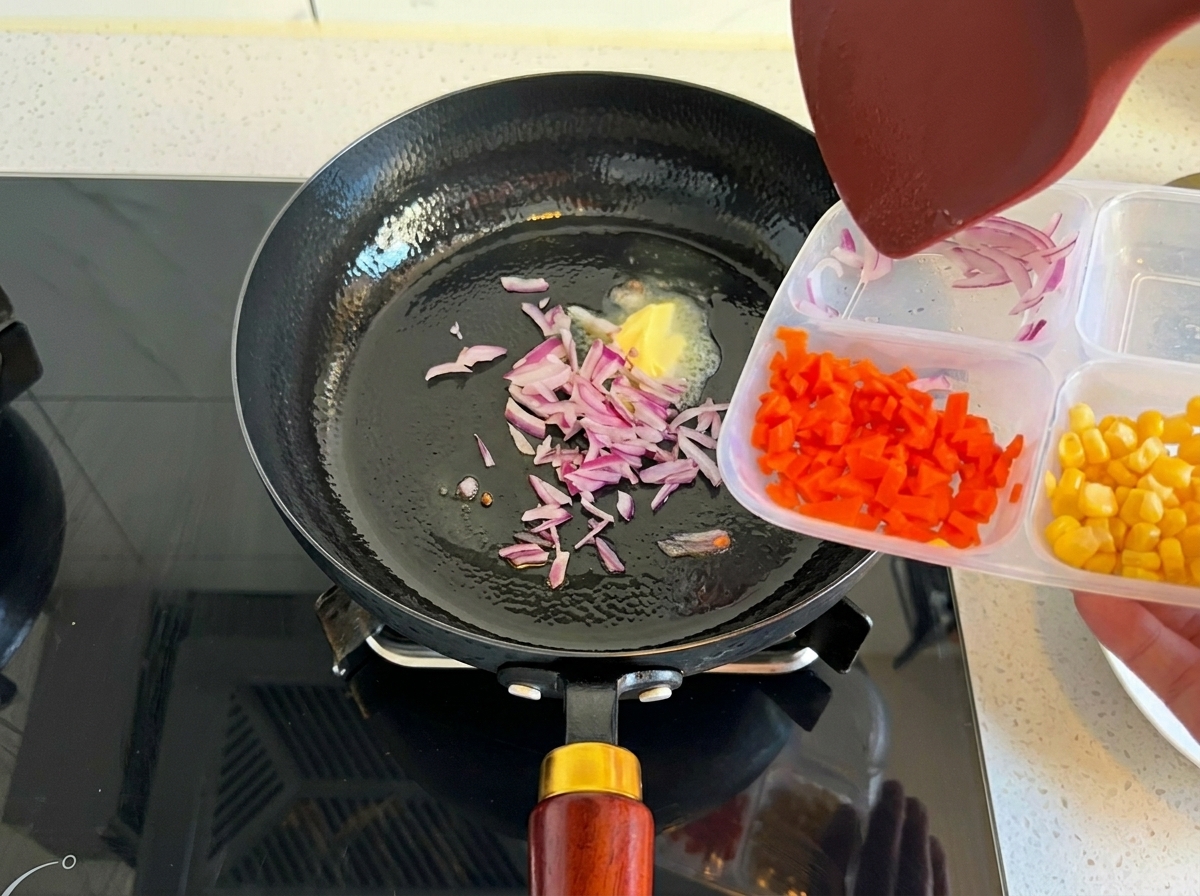 Gehackte rote Zwiebeln werden aus einem Behälter in eine heiße Pfanne mit geschmolzener Butter gegeben.