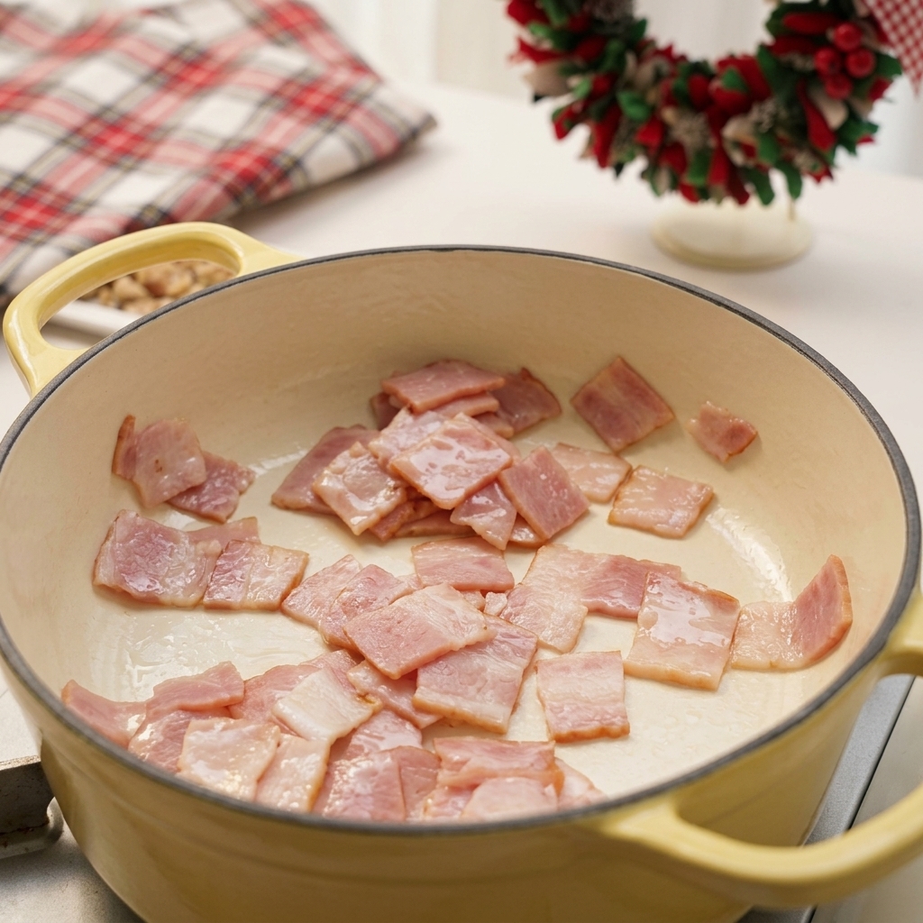 Gehackte Speckwürfel braten in einem Topf und lassen Fett aus.