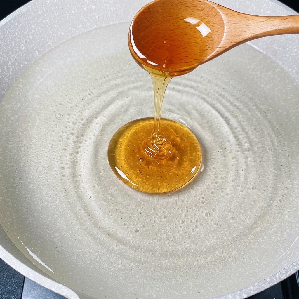 Ein Holzlöffel gießt einen Strahl Speiseöl in einen Topf mit kochendem Wasser.