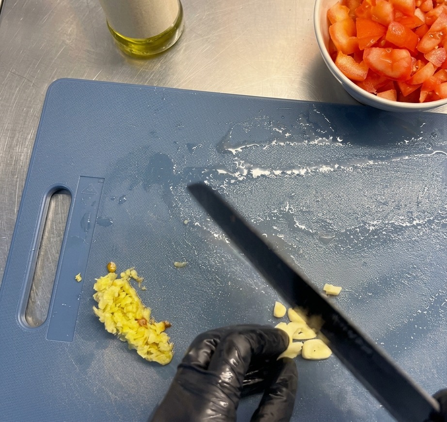 Frische Knoblauchzehen werden in feine Scheiben geschnitten.