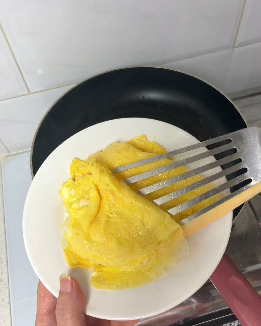Speckstreifen braten in einer heißen, schwarzen Antihaft-Pfanne, wobei das Fett austritt.