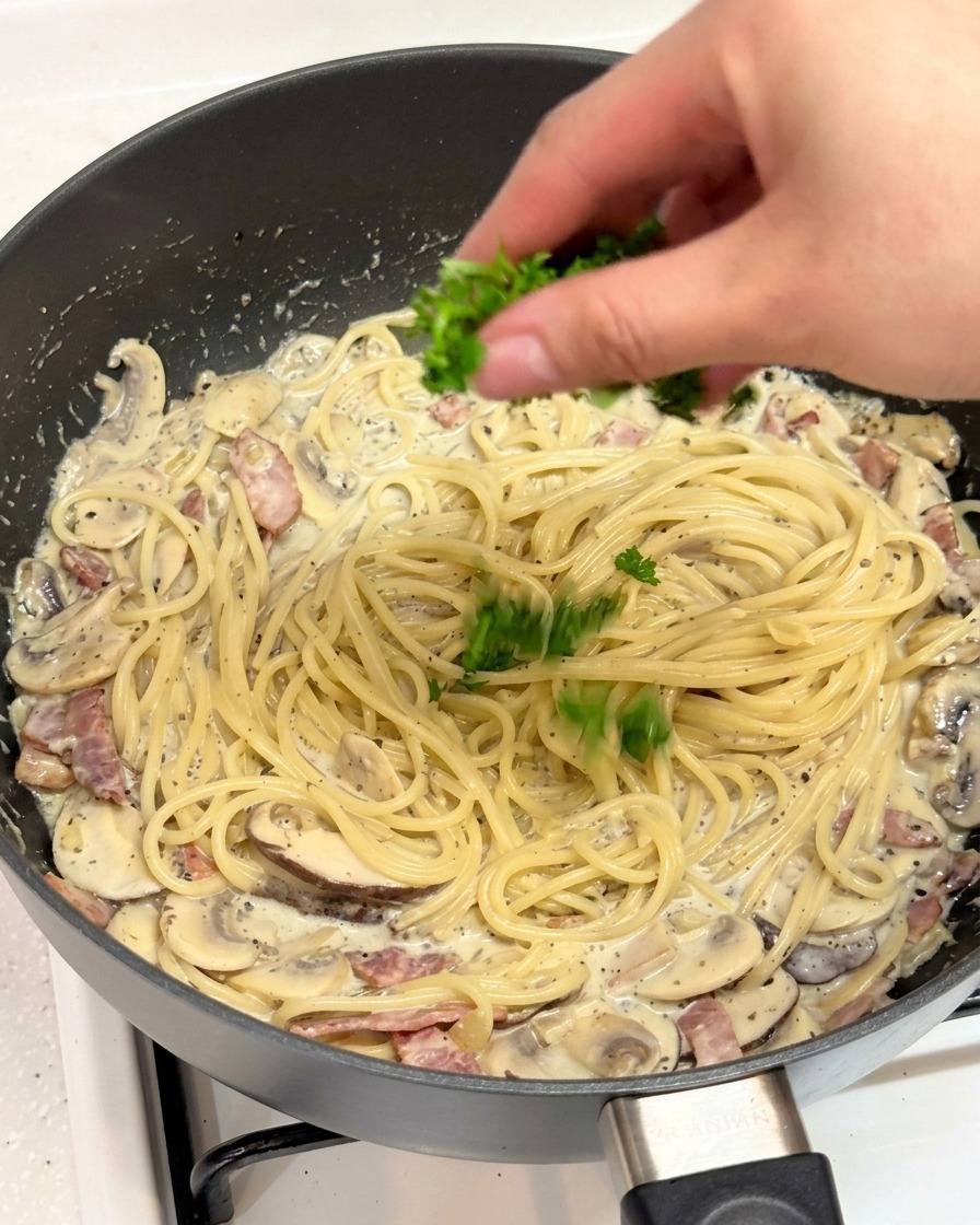 Frisch gehackte Petersilie wird über die cremige Trüffel-Pasta gestreut.
