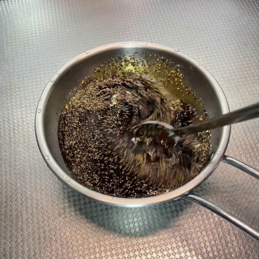 Die dunkle Pfeffersauce wird mit einem Löffel in einer Schüssel verrührt.