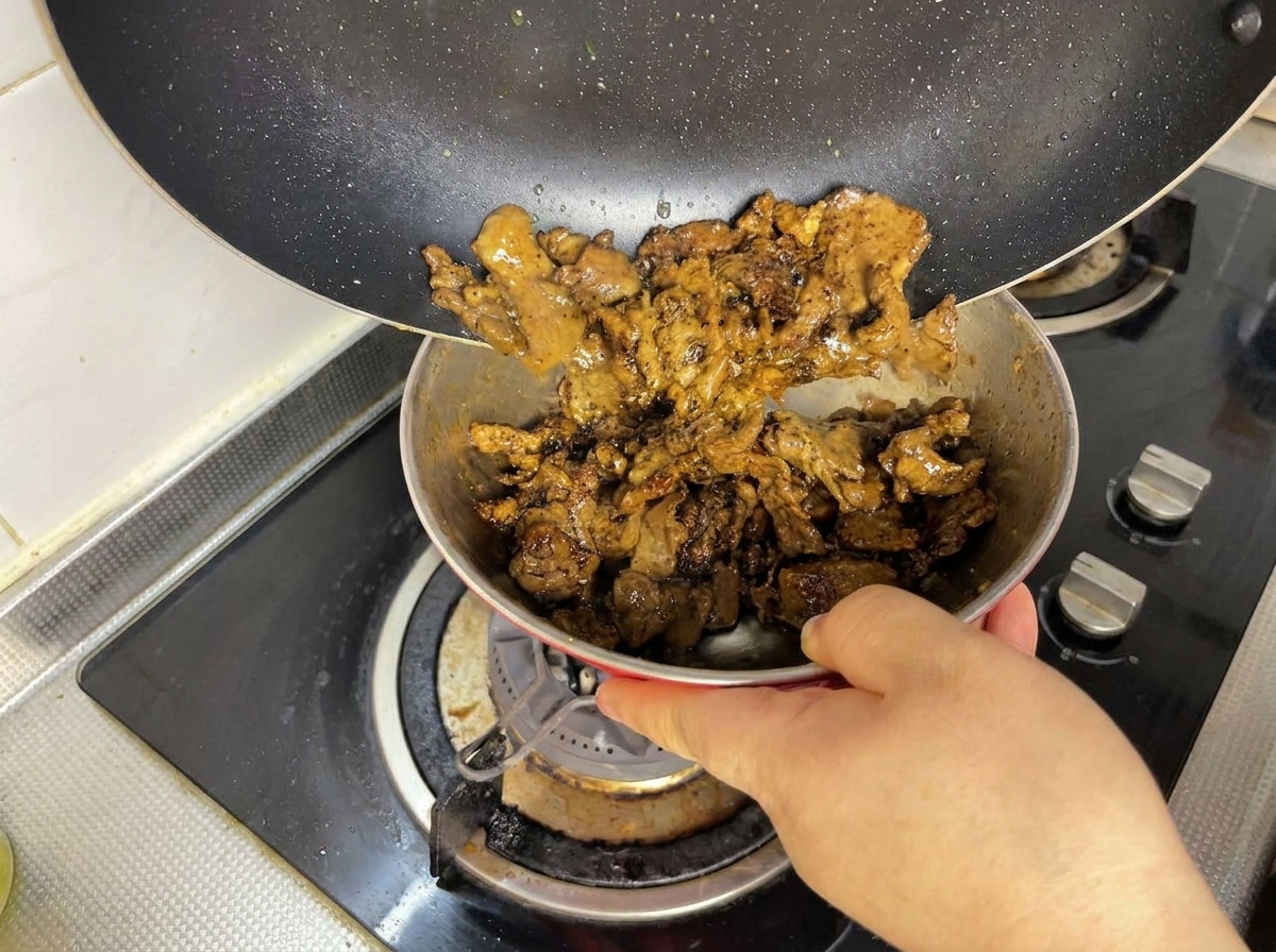 Gebräuntes Fleisch wird aus der Pfanne in eine Schüssel umgefüllt.