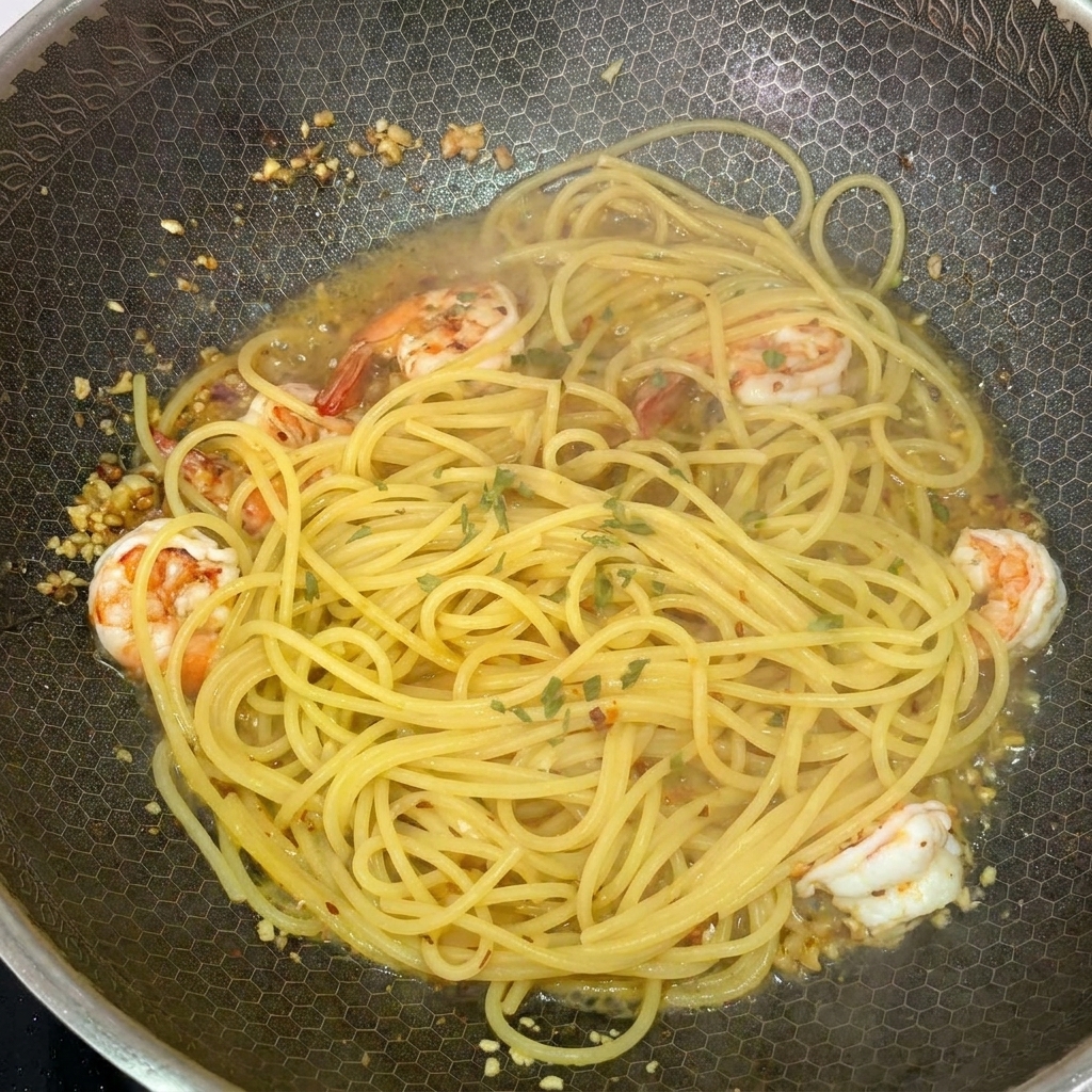 Frisch gehackte Petersilie wird über die fertige Pasta im Wok gestreut.