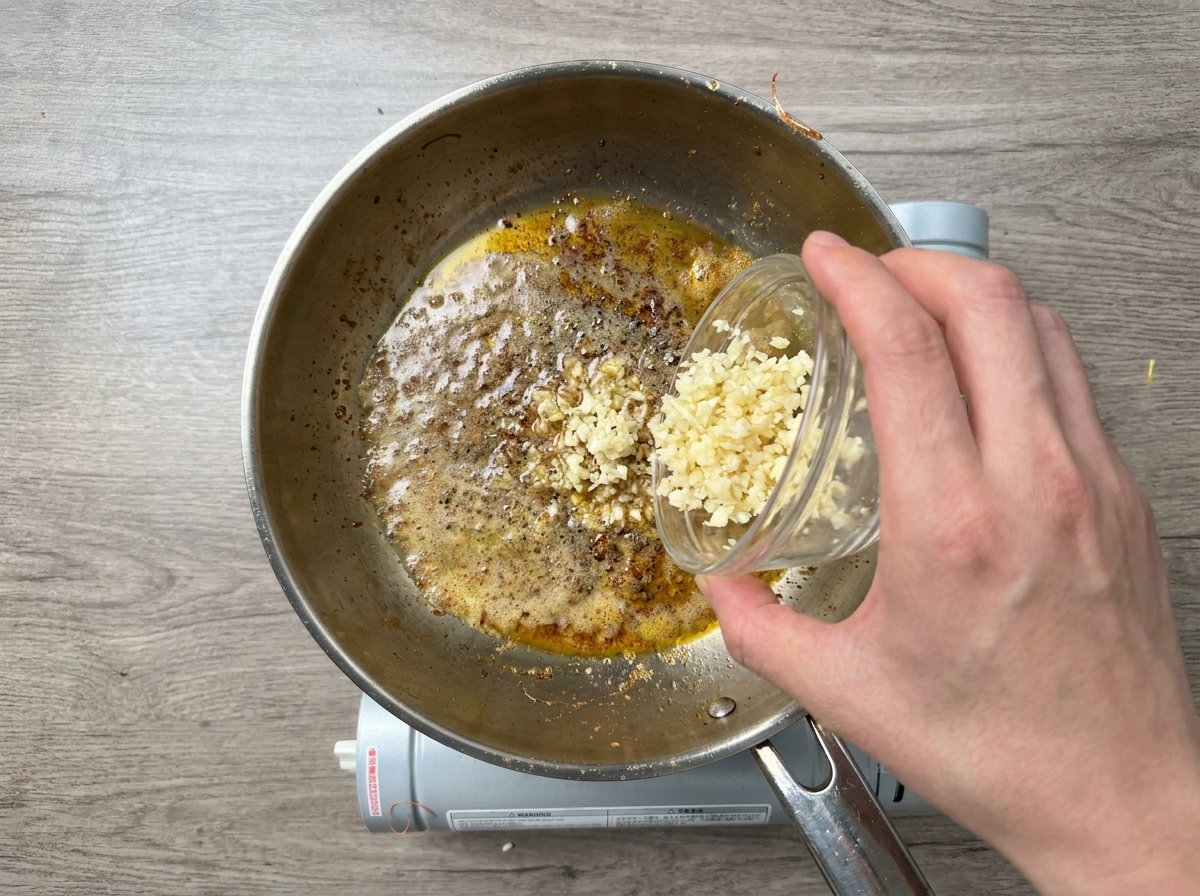 Gehackter Knoblauch wird in die Pfanne gegeben.
