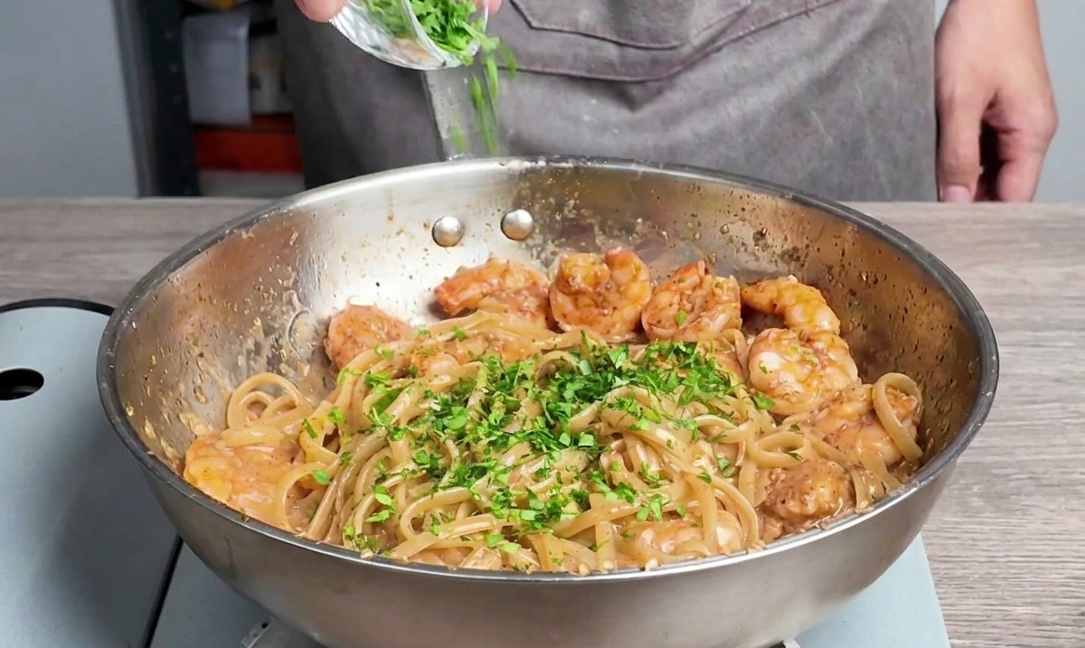 Frische Petersilie wird über die Pasta gestreut.