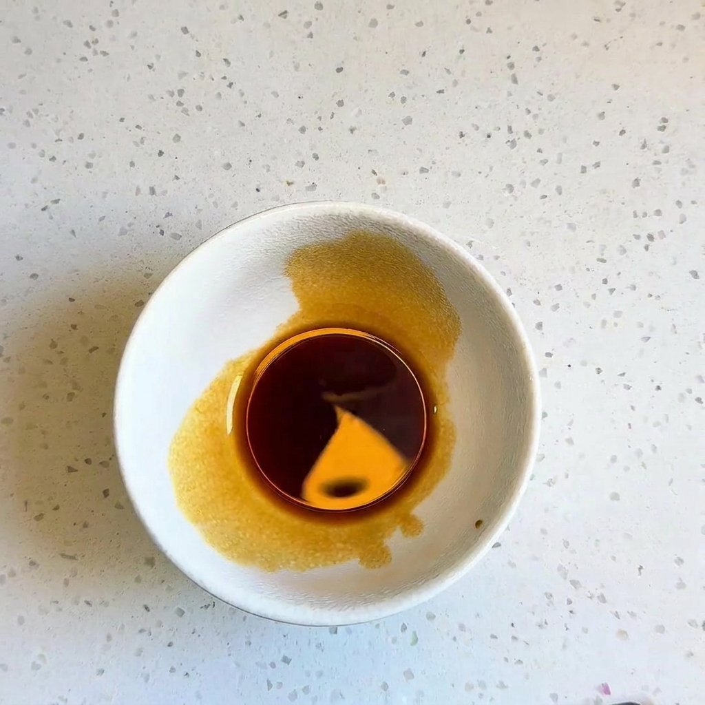 Eine kleine weiße Schüssel mit einer dunkelbraunen, fertig gemischten Würzsauce.
