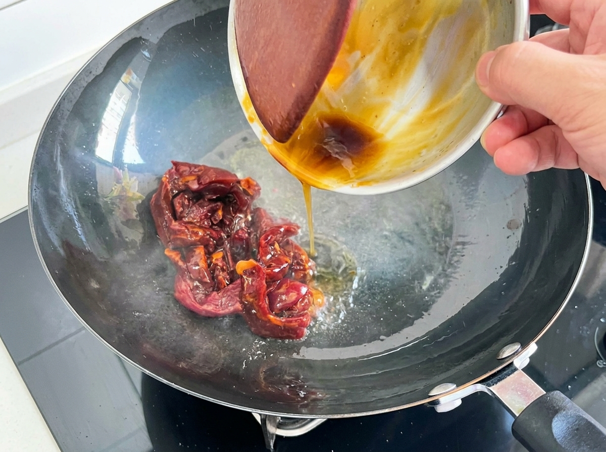 Fleischstreifen werden im heißen Wok schnell gewendet.