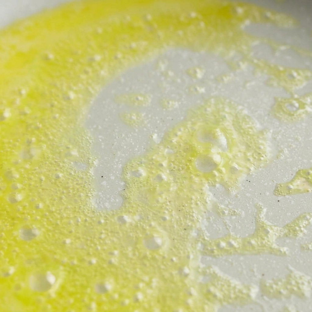 Butter schmilzt und schäumt leicht in einer hellen Pfanne.