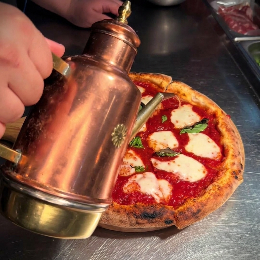 Goldenes Olivenöl wird aus einer Kupferkanne über die geschnittene Pizza gegossen.