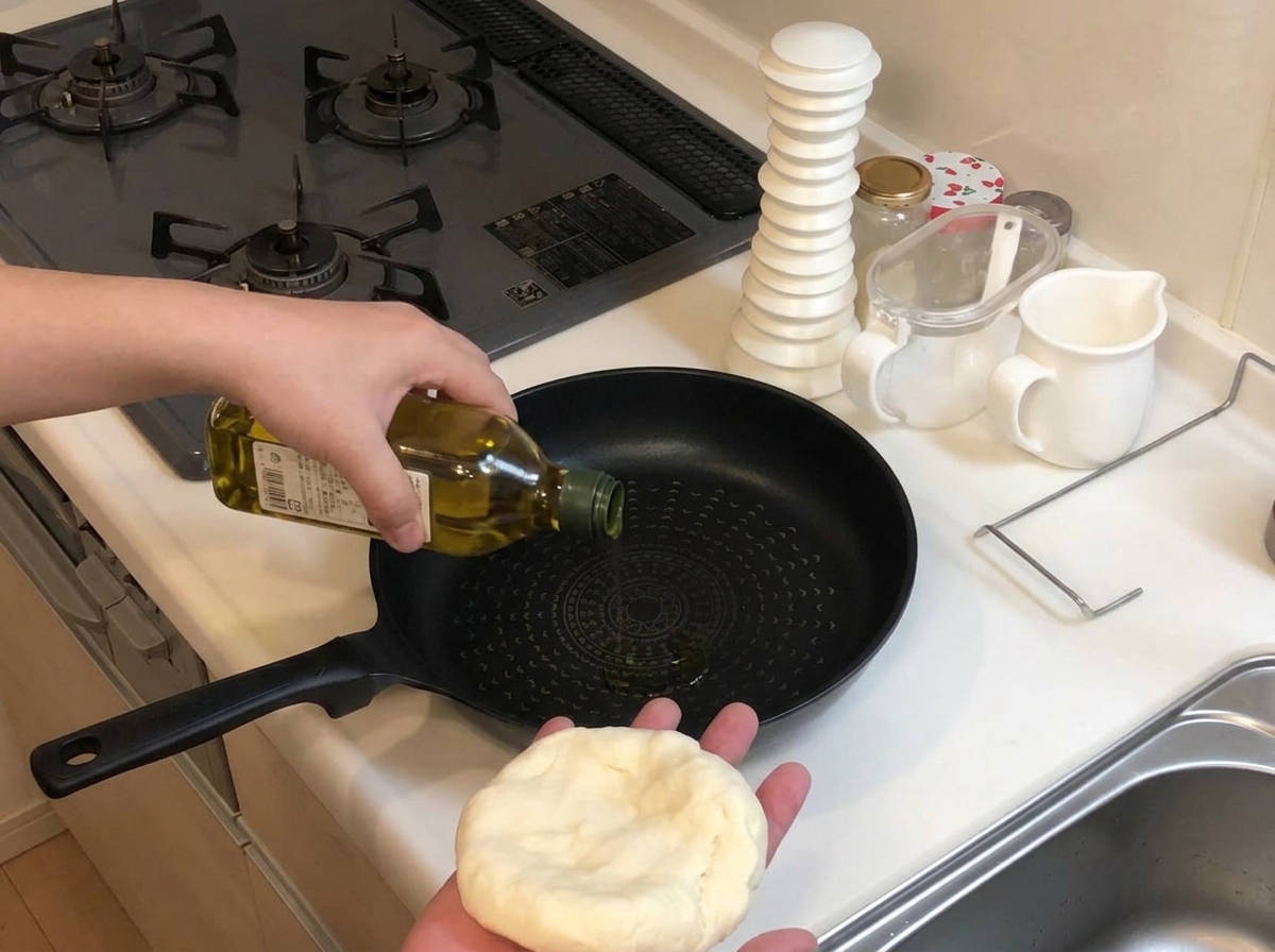Olivenöl wird in eine kalte, schwarze Bratpfanne gegossen.
