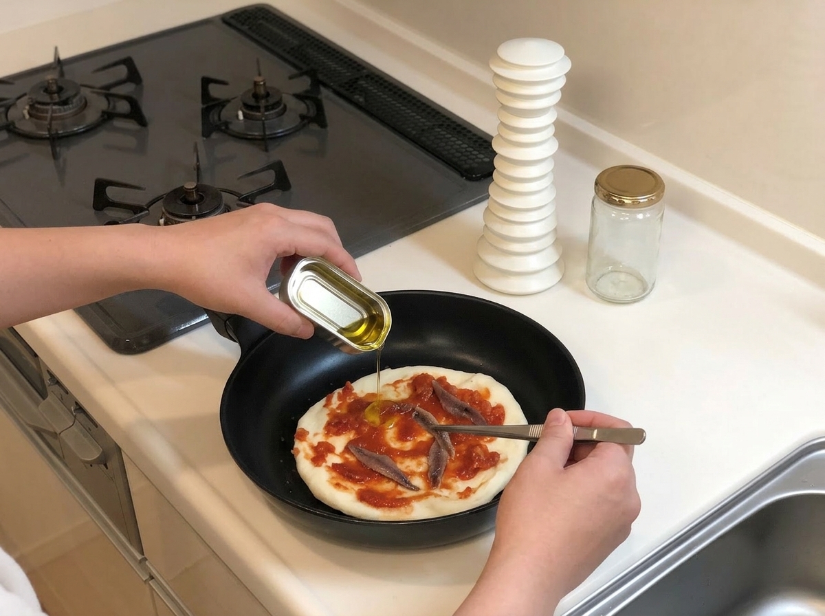 Ganze Sardellenfilets werden mit einer Pinzette auf der Pizzasauce verteilt.