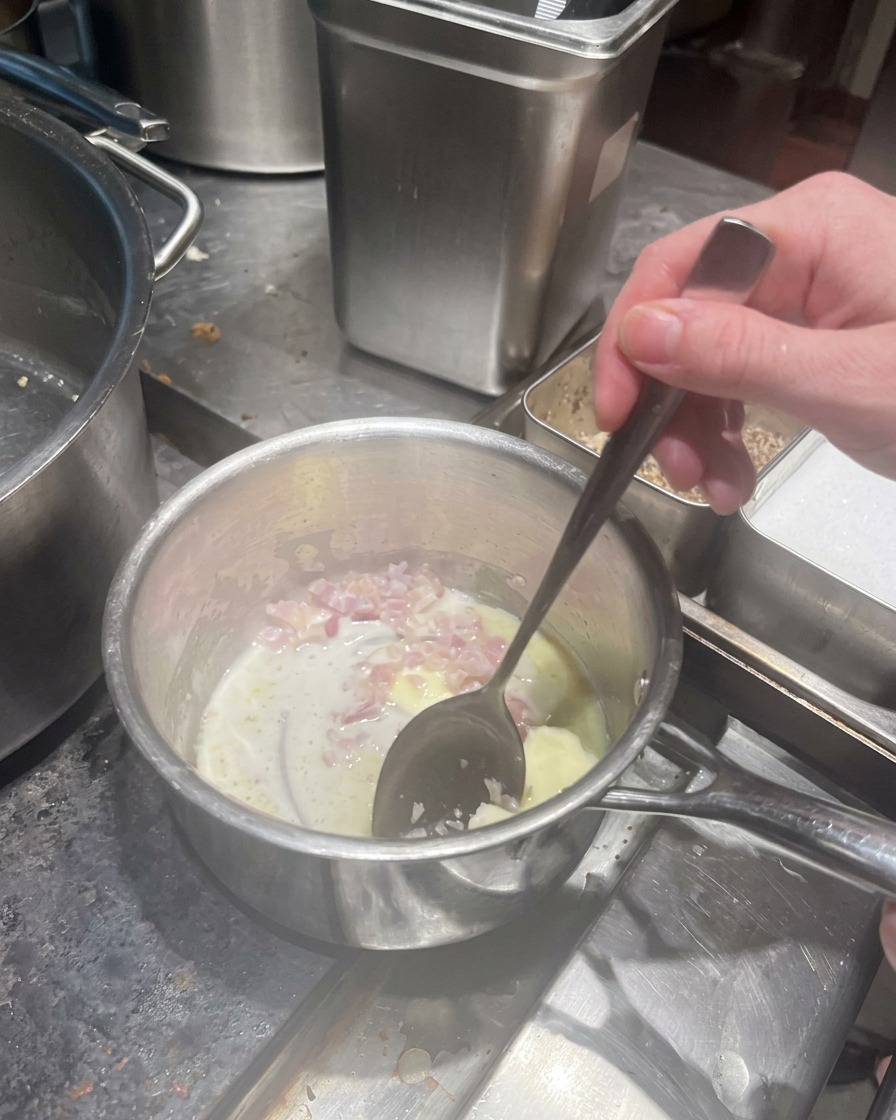 Fein gewürfelte Schalotten dünsten in geschmolzener Butter in einem kleinen Topf.