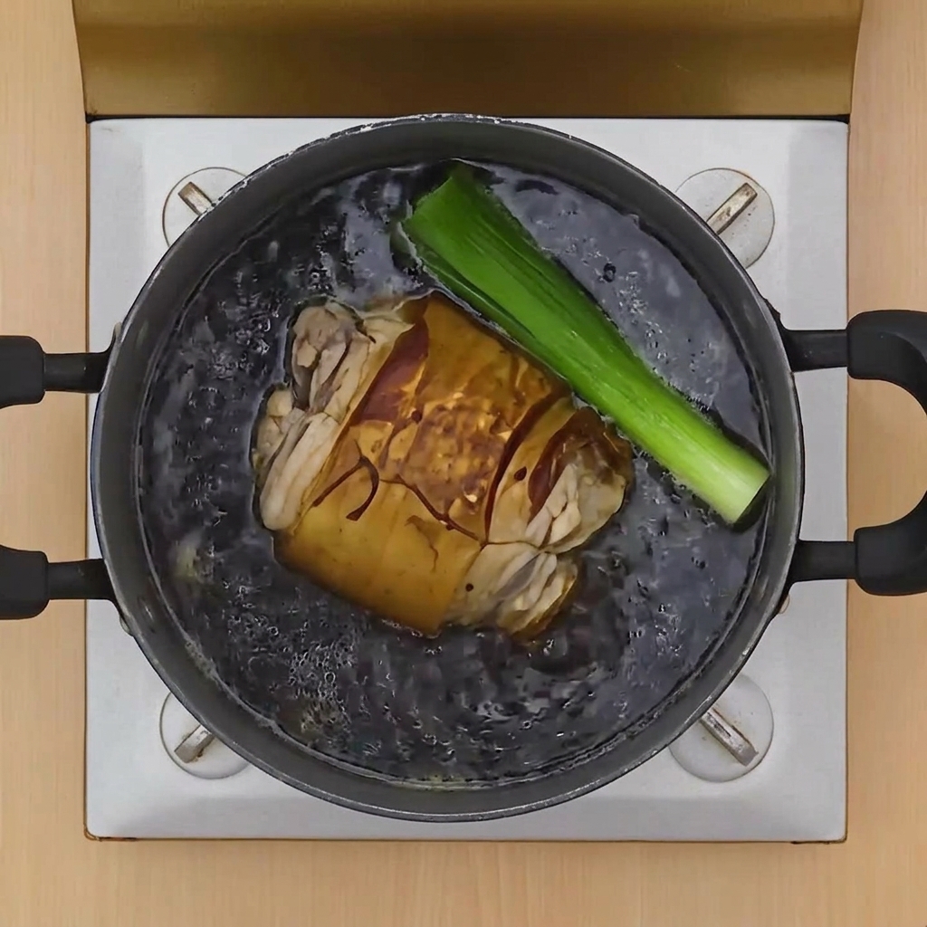 Frühlingszwiebeln, Knoblauch und Ingwer werden zum Fleisch in den Topf gegeben.