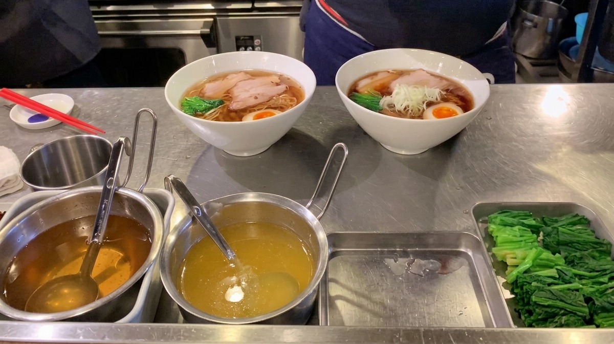 Fein gehackte weiße Frühlingszwiebeln in der Mitte einer dampfenden Schüssel Ramen aufgetürmt.
