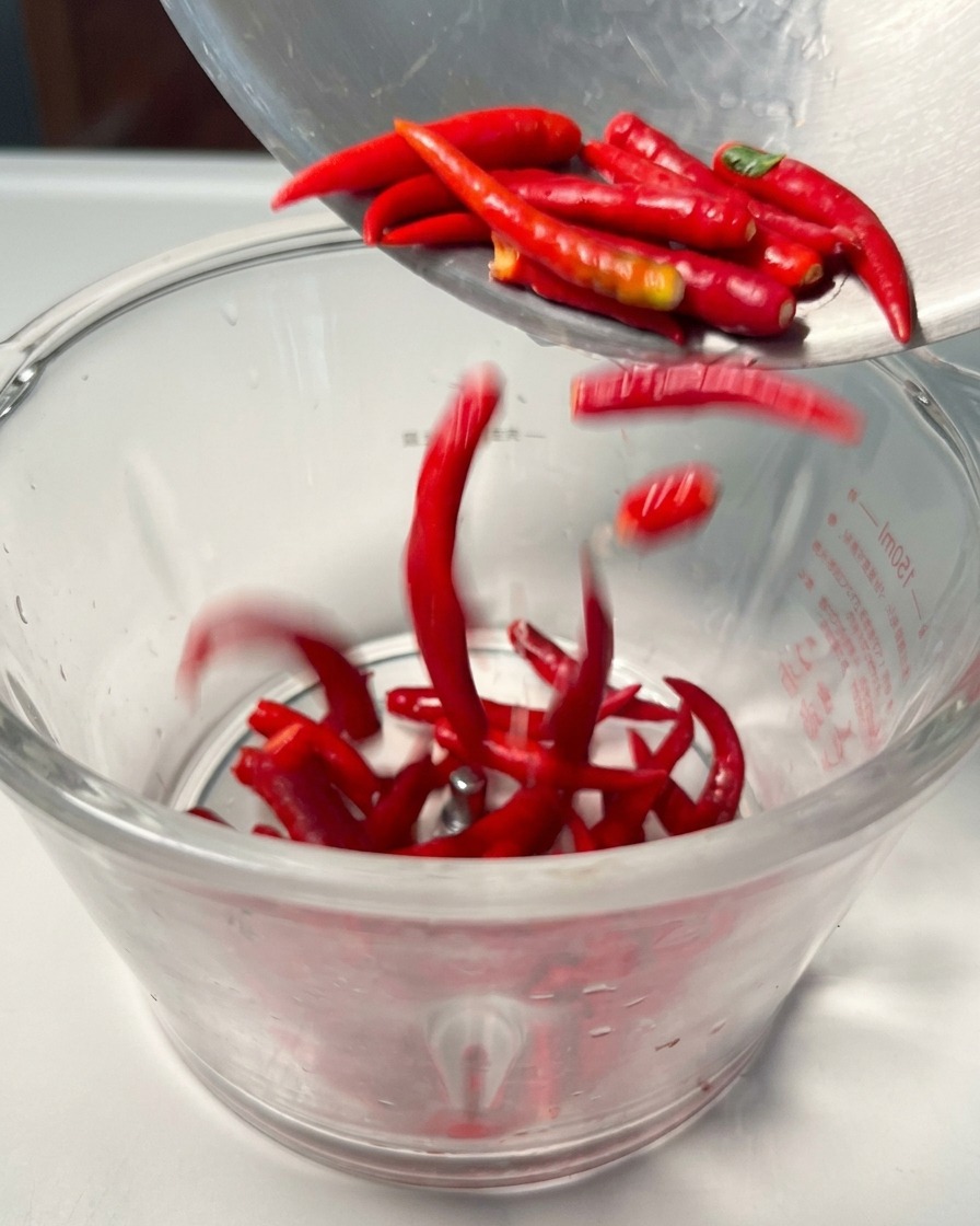 Frische rote Chilischoten in einem Mixerbehälter.