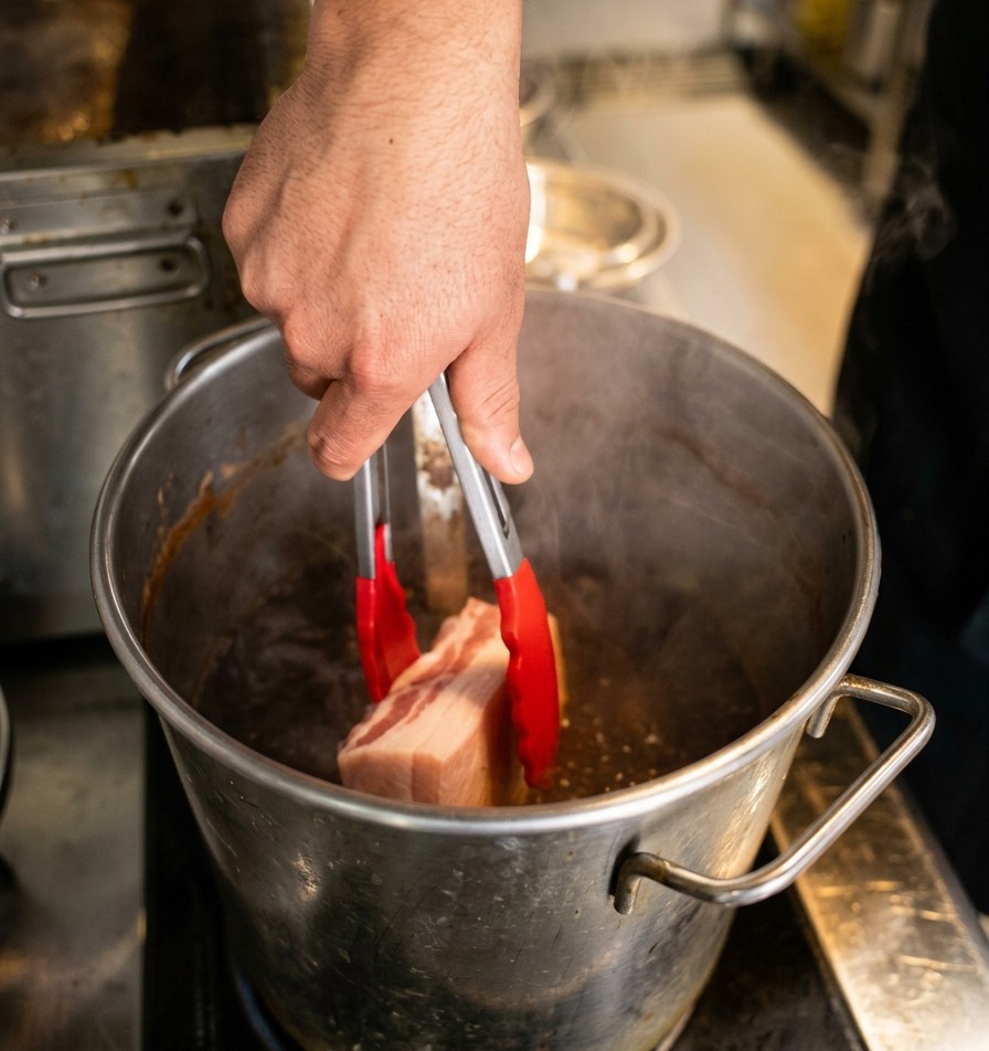 Die angebratene Fleischrolle wird vorsichtig in die dunkle Sauce gleiten gelassen.