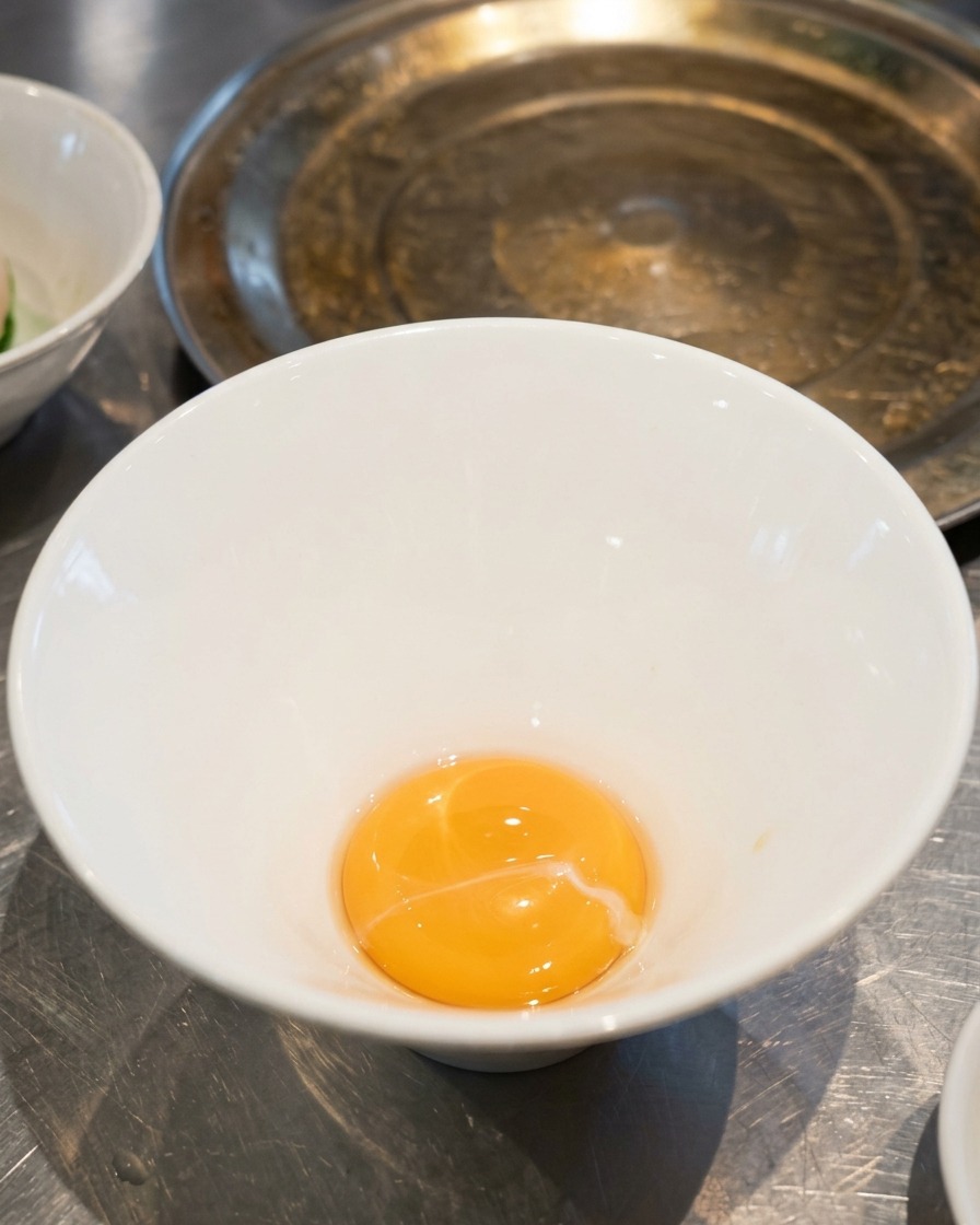 Ein wenig goldgelbe Salz-Tare am Boden einer leeren weißen Ramen-Schüssel.