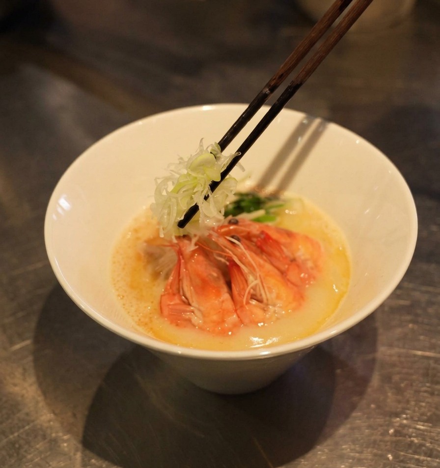 Stäbchen platzieren fein geschnittene weiße Frühlingszwiebeln auf den Garnelen-Ramen.