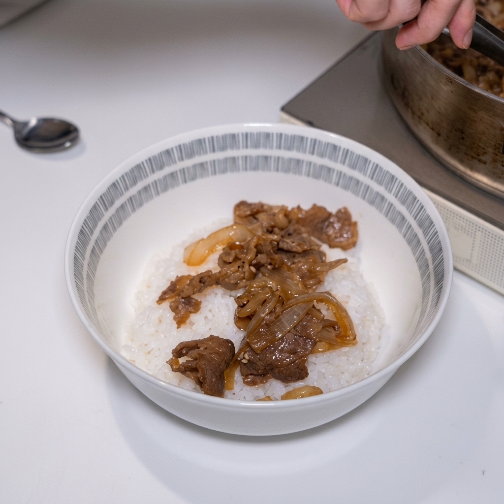 Zartes Fleisch und Zwiebeln werden mit einer Zange auf eine Schüssel mit weißem Reis gelegt.