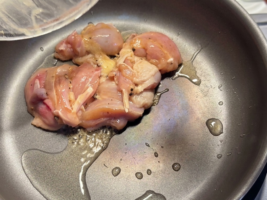 Marinierte Hähnchenstücke werden in einer heißen Pfanne mit etwas Öl goldbraun angebraten.