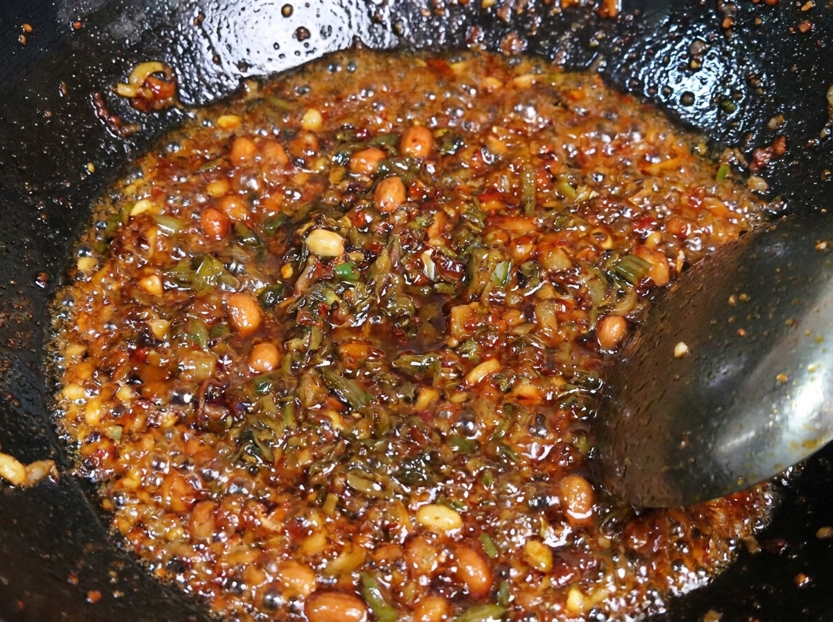 Eine Mischung aus gewürztem Hackfleisch und dunklem Yibin-Senfgrün wird zusammen in einem heißen Wok gebraten.