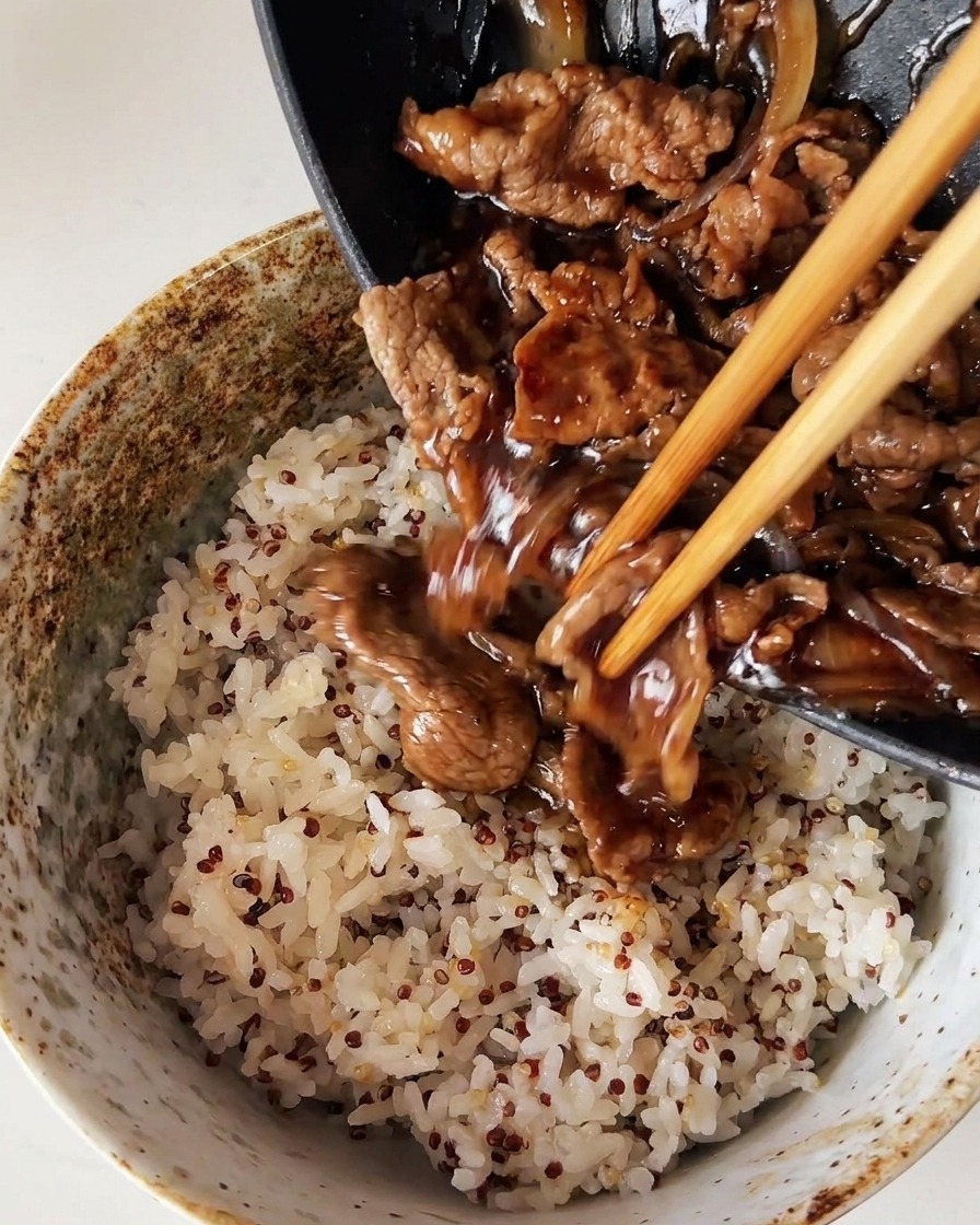 Gegartes Rindfleisch und Zwiebeln werden aus einer Pfanne über eine Schale mit gedämpftem weißem Reis und Quinoa gegeben.