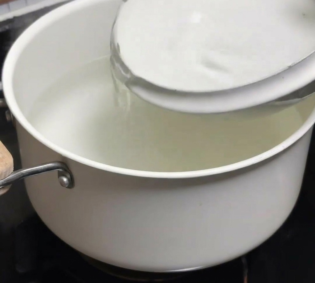 Eine Schale mit kaltem Wasser wird in einen Topf mit frisch abgekochtem, heißem Wasser gegossen.