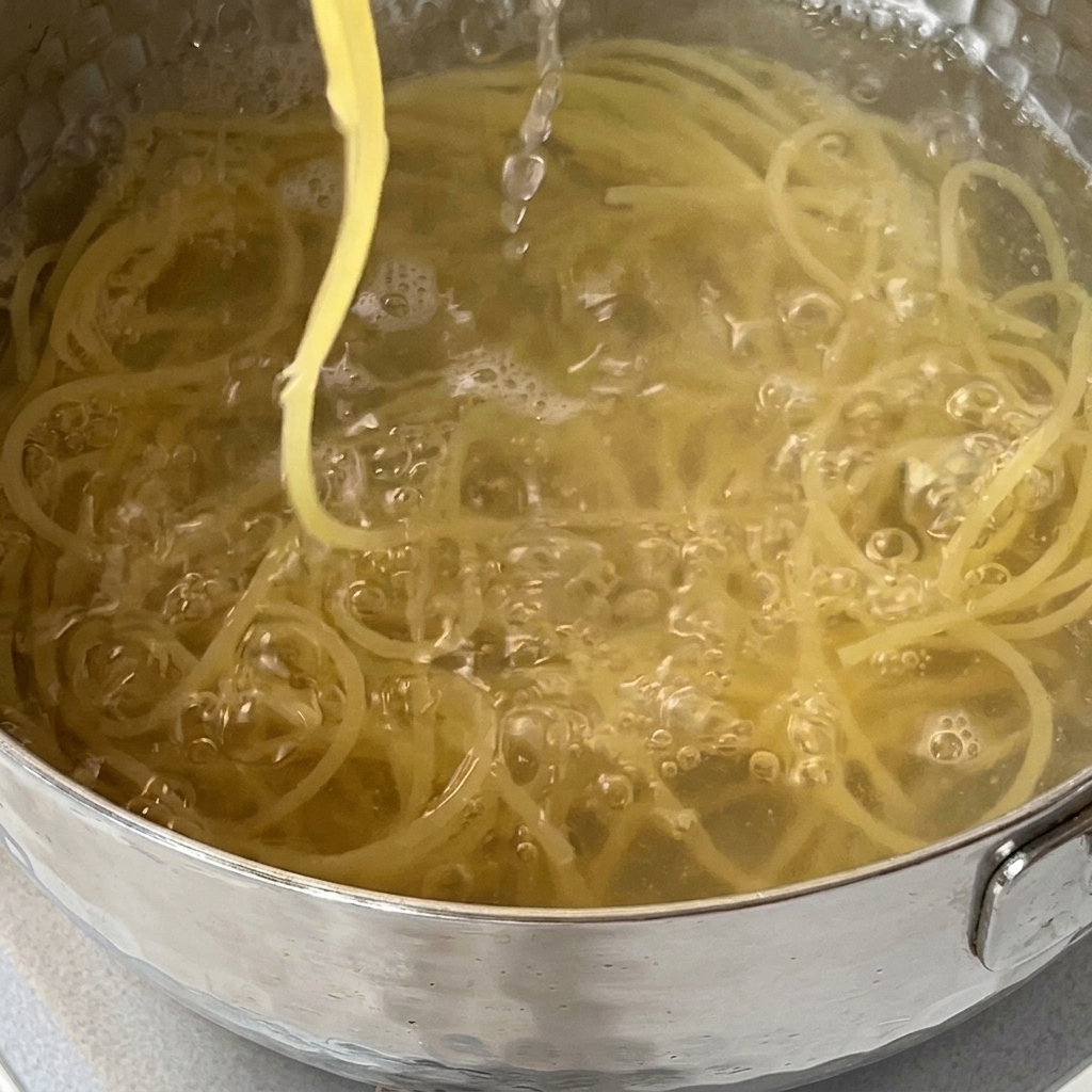 Spaghetti werden in einem Sieb im Spülbecken abgegossen.