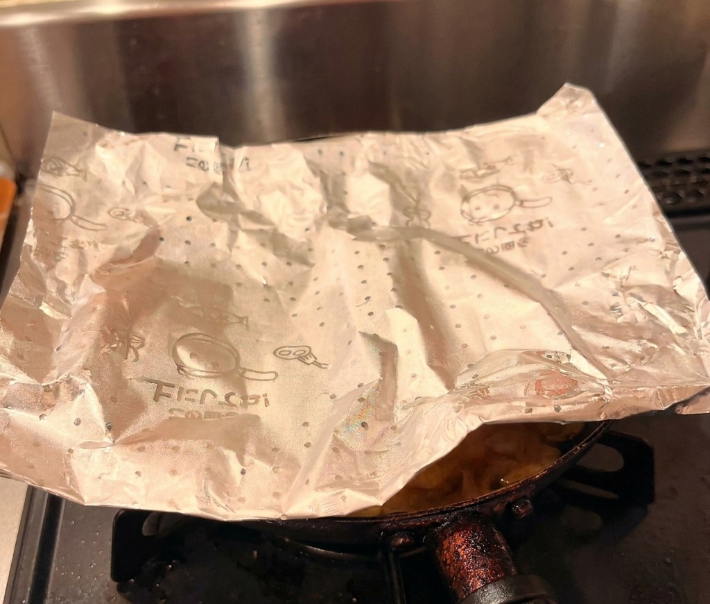 Das fertige Hähnchen-Ei-Topping wird vorsichtig aus der Pfanne auf eine Schale mit weißem Reis gleiten gelassen.