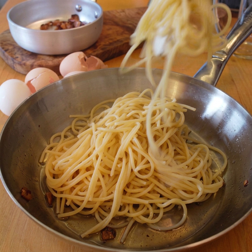 Spaghetti werden mit einer Zange in die Pfanne mit dem Speckfett gegeben.