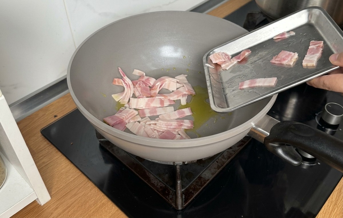 Rohe Speckstreifen werden in eine Pfanne mit Olivenöl gegeben.