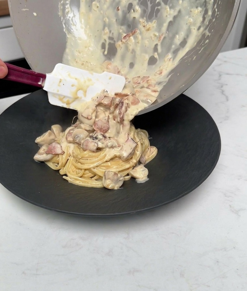 Restliche Sauce, Pilze und Speck werden aus der Pfanne über die Pasta gegossen.