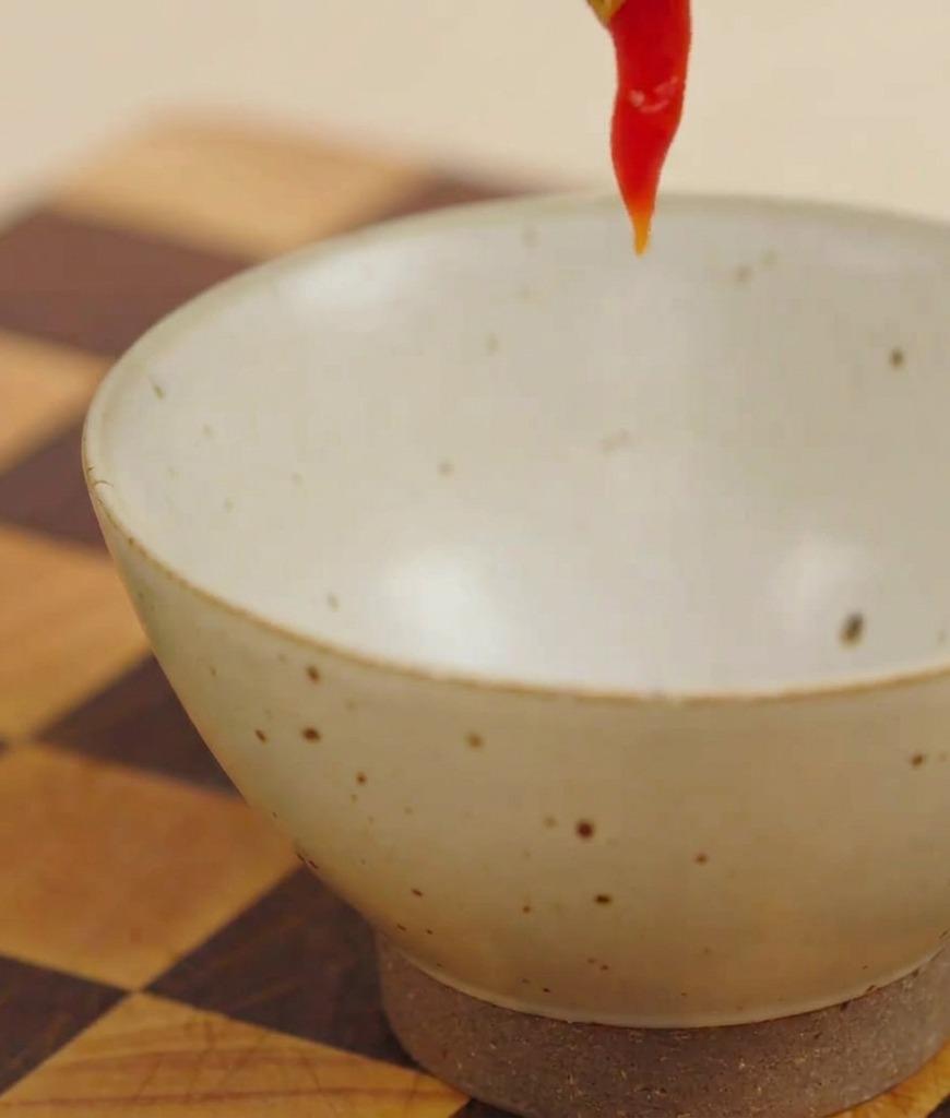 Roter Ketchup wird in eine kleine Schüssel gedrückt, um Burgersoße zuzubereiten.