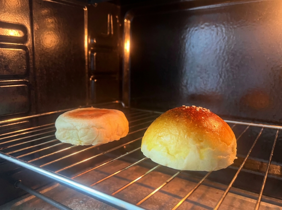 Zwei Hälften eines Burgerbrötchens toasten auf einem Rost im Ofen.
