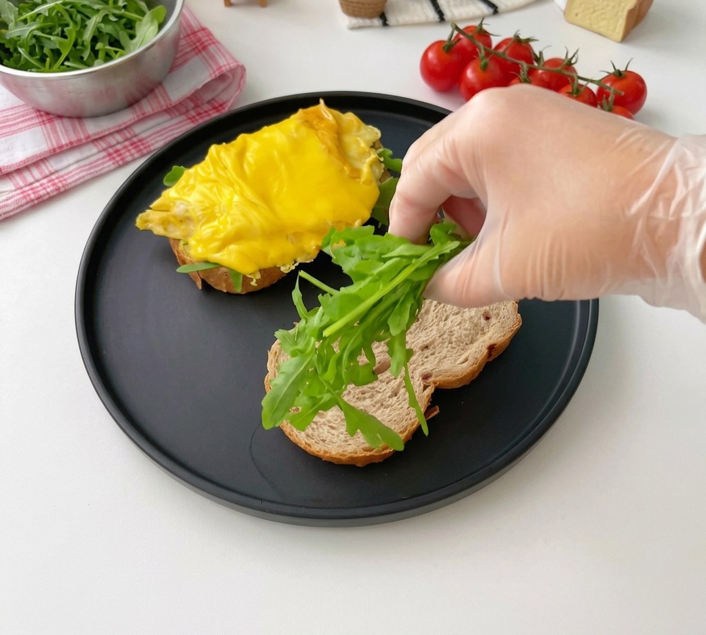 Frischer Rucola wird auf eine geröstete Scheibe Mehrkornbrot gelegt.