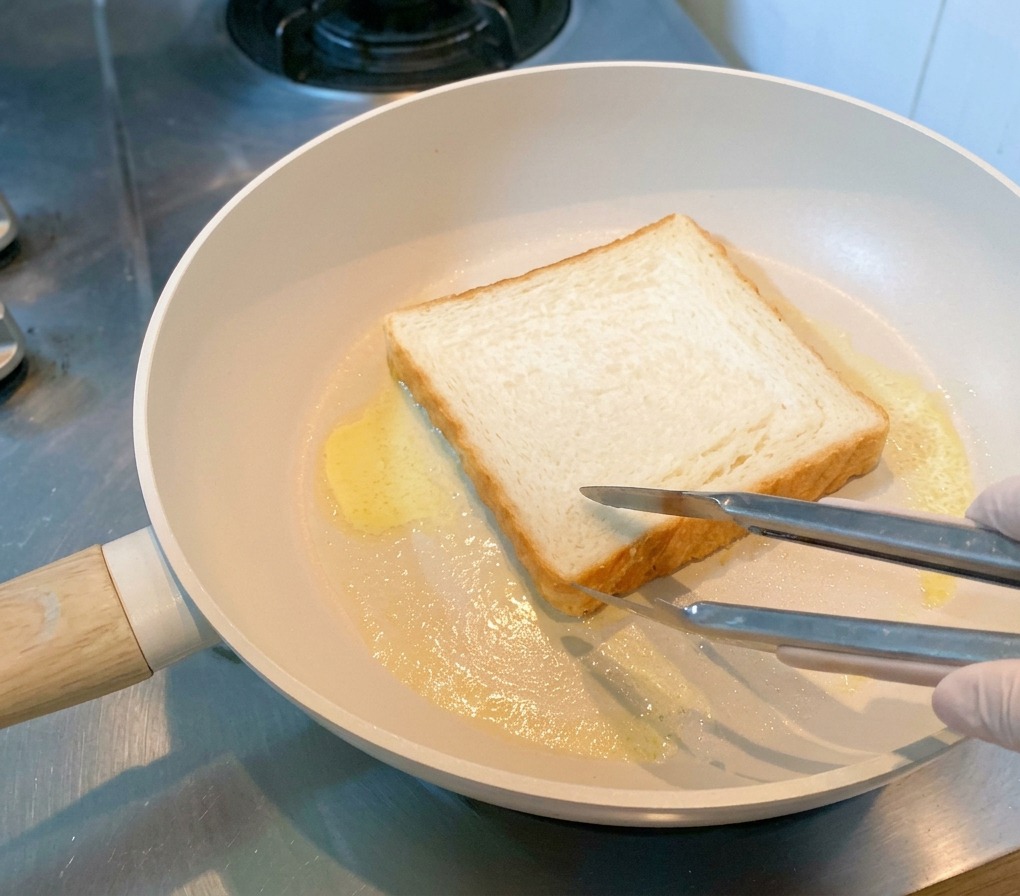 Eine Scheibe Toastbrot wird in geschmolzener Butter goldbraun geröstet.