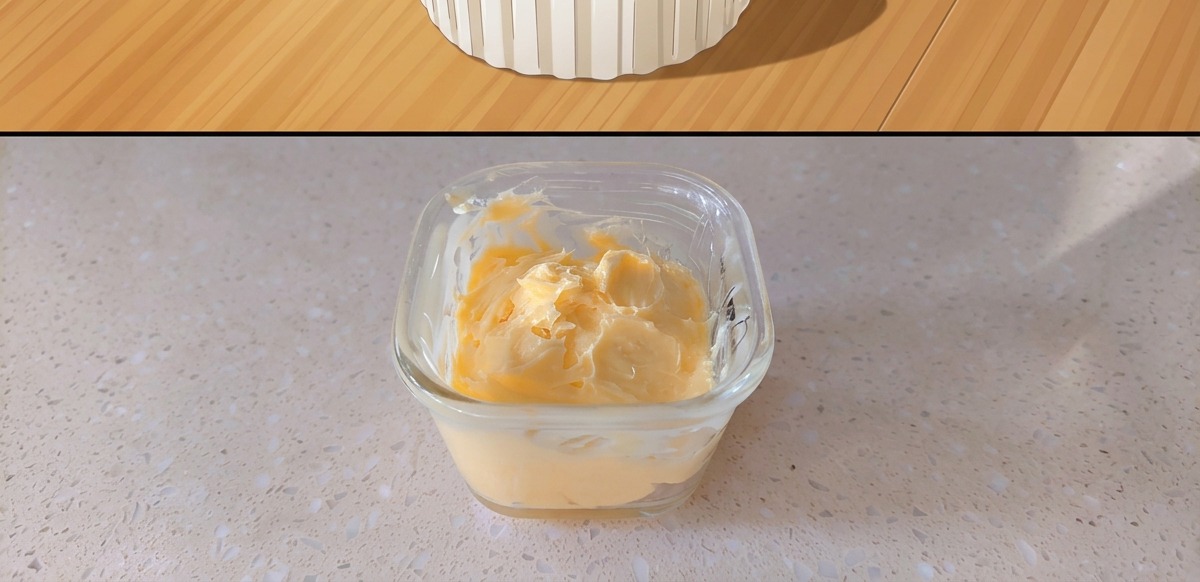 Ein kleiner Glasbehälter mit gemischter gelber Senfbutter.