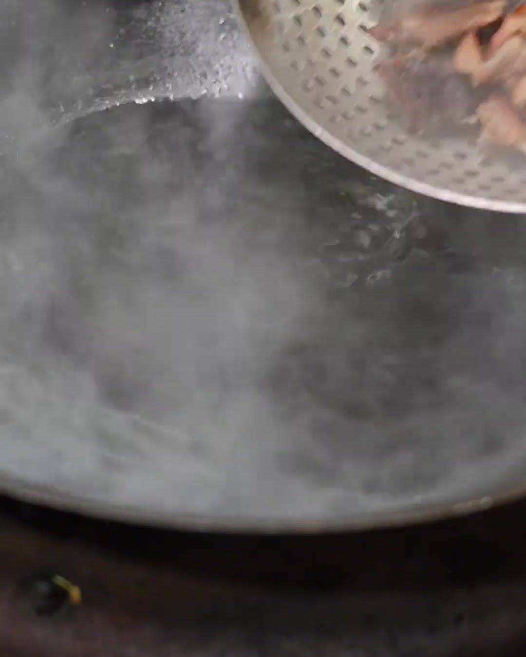 Gepökelte Rippchen werden abgegossen und in einen frischen Topf mit kochendem, sauberem Wasser in einem Wok gegeben.