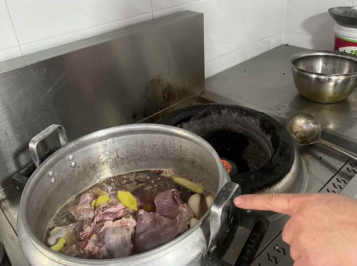 Ein großer Topf mit Fleisch und Brühe steht auf dem Herd.