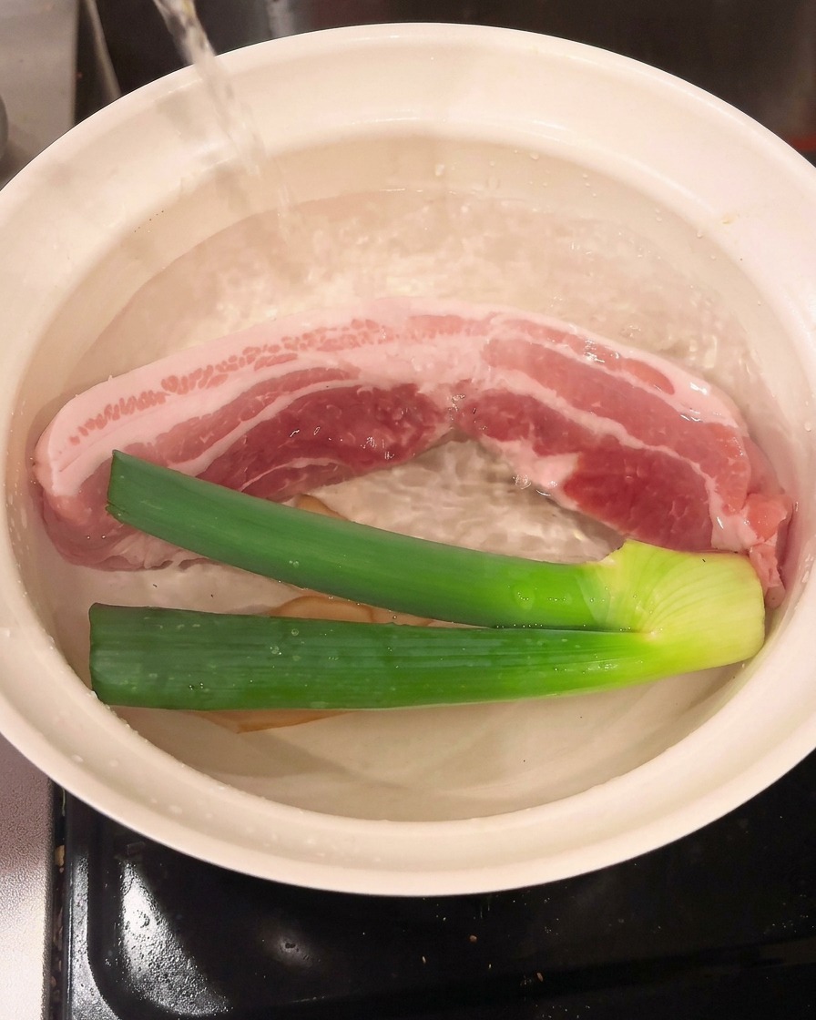 Kochwein wird in den Topf gegossen und vermischt sich mit dem Fleisch und den Aromaten.