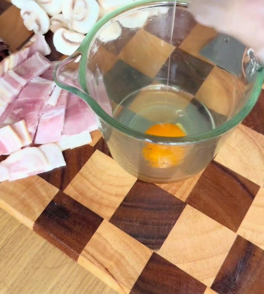 Eier, Parmesan und Trüffelsauce werden in einem Messbecher glatt miteinander verrührt.