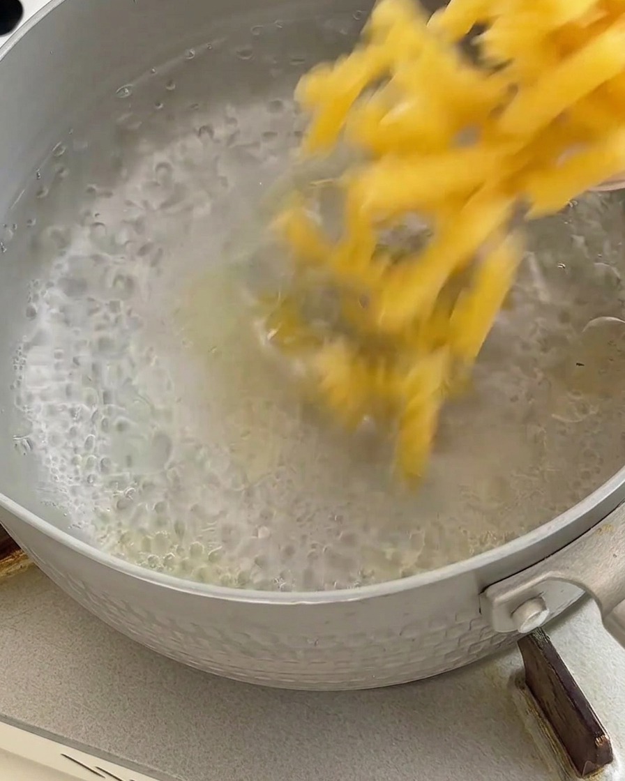 Gekochte Nudeln werden nach dem Kochen in einem Metallsieb abgetropft.