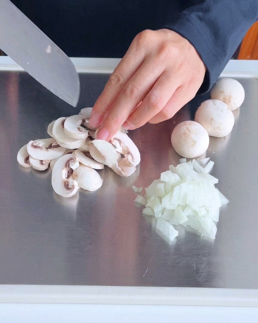 Baconstreifen werden auf einem Schneidebrett aus Metall gewürfelt.