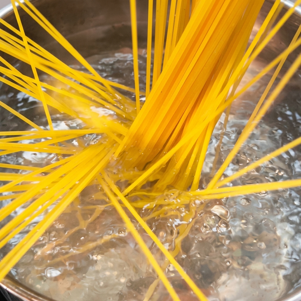 Spaghetti kochen in einem großen Topf mit sprudelndem Salzwasser.