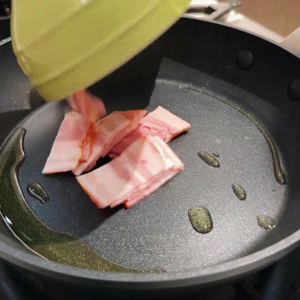 Knusprige Baconstücke braten in einer heißen Pfanne mit Öl.